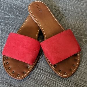 Red slip on suede sandals.